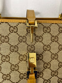 Fermoir doré et languette centrale du sac Gucci Jackie à motif GG