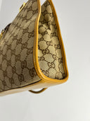 Côté du sac Gucci à motif GG et finitions moutarde, vue en biais
