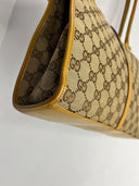 Ouverture latérale du sac Gucci à motif GG et bordure moutarde