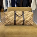 Sac de voyage Dior 55 à motif monogrammé beige et marron, vue de face chez MAJO